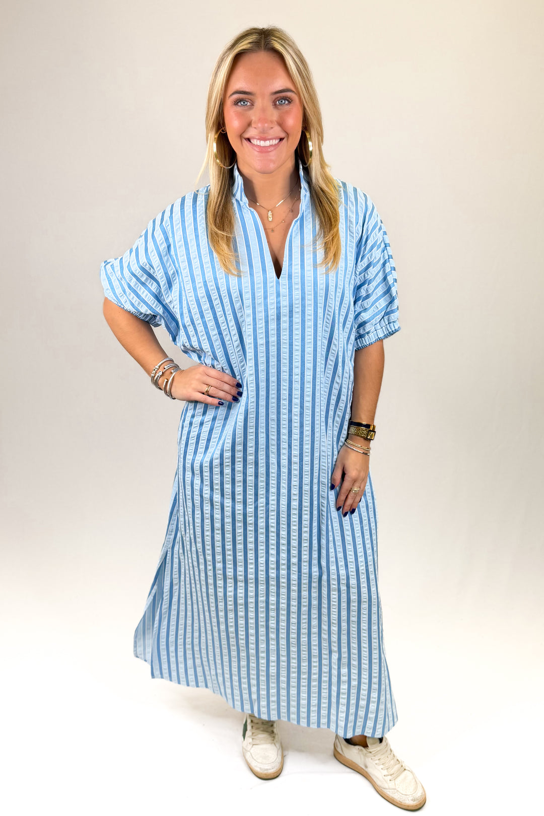 Woman wearing a blue and white striped dress on a plain background