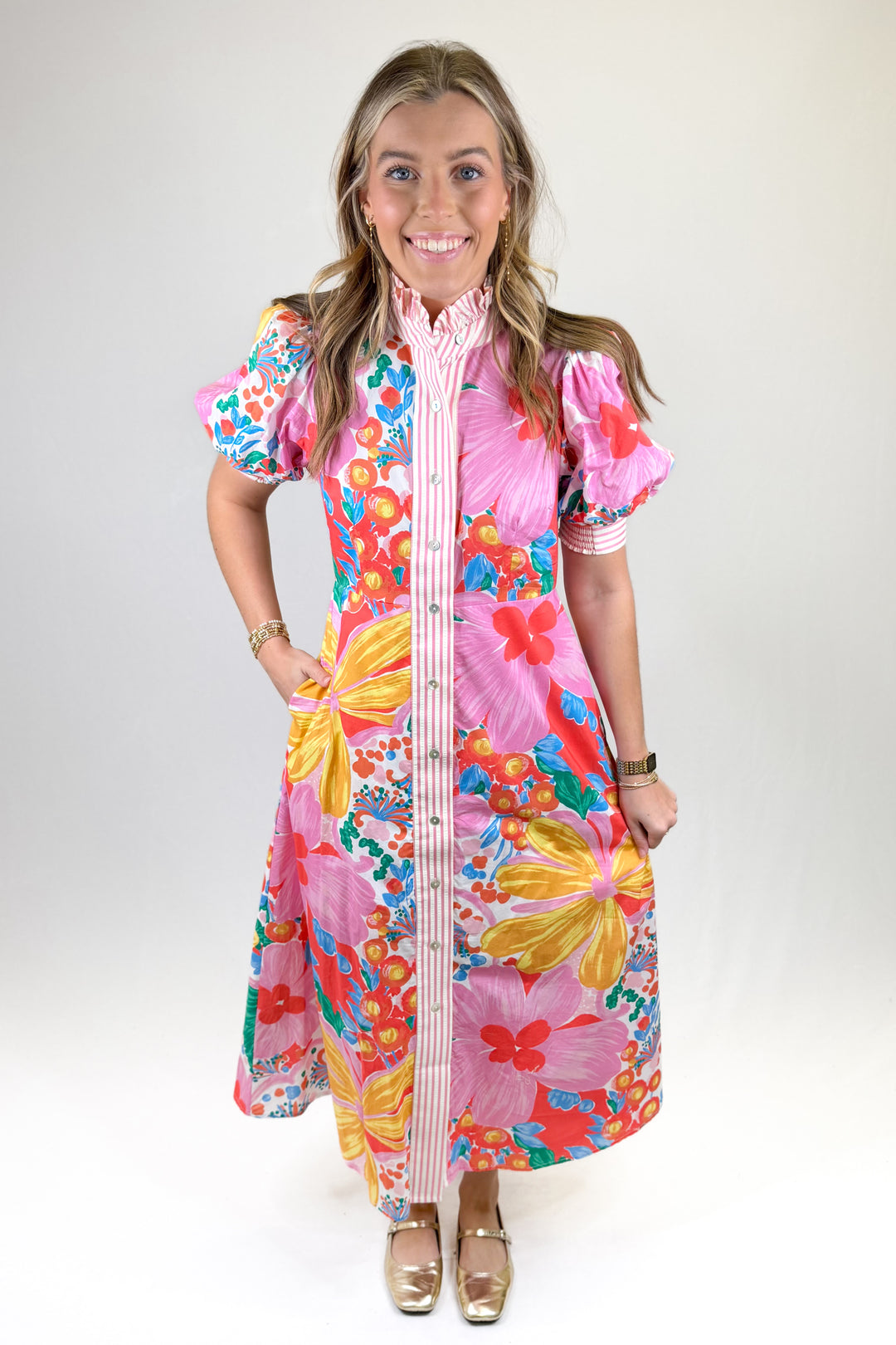 Woman wearing a colorful floral dress with a white background