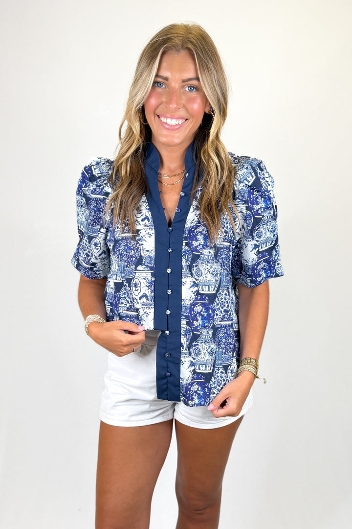 Woman wearing a blue patterned shirt with a white background