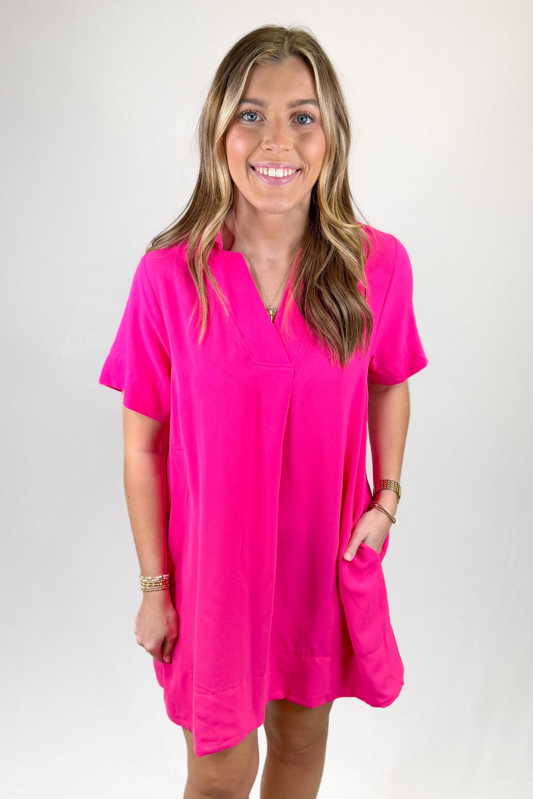 Woman wearing a bright pink dress on a white background