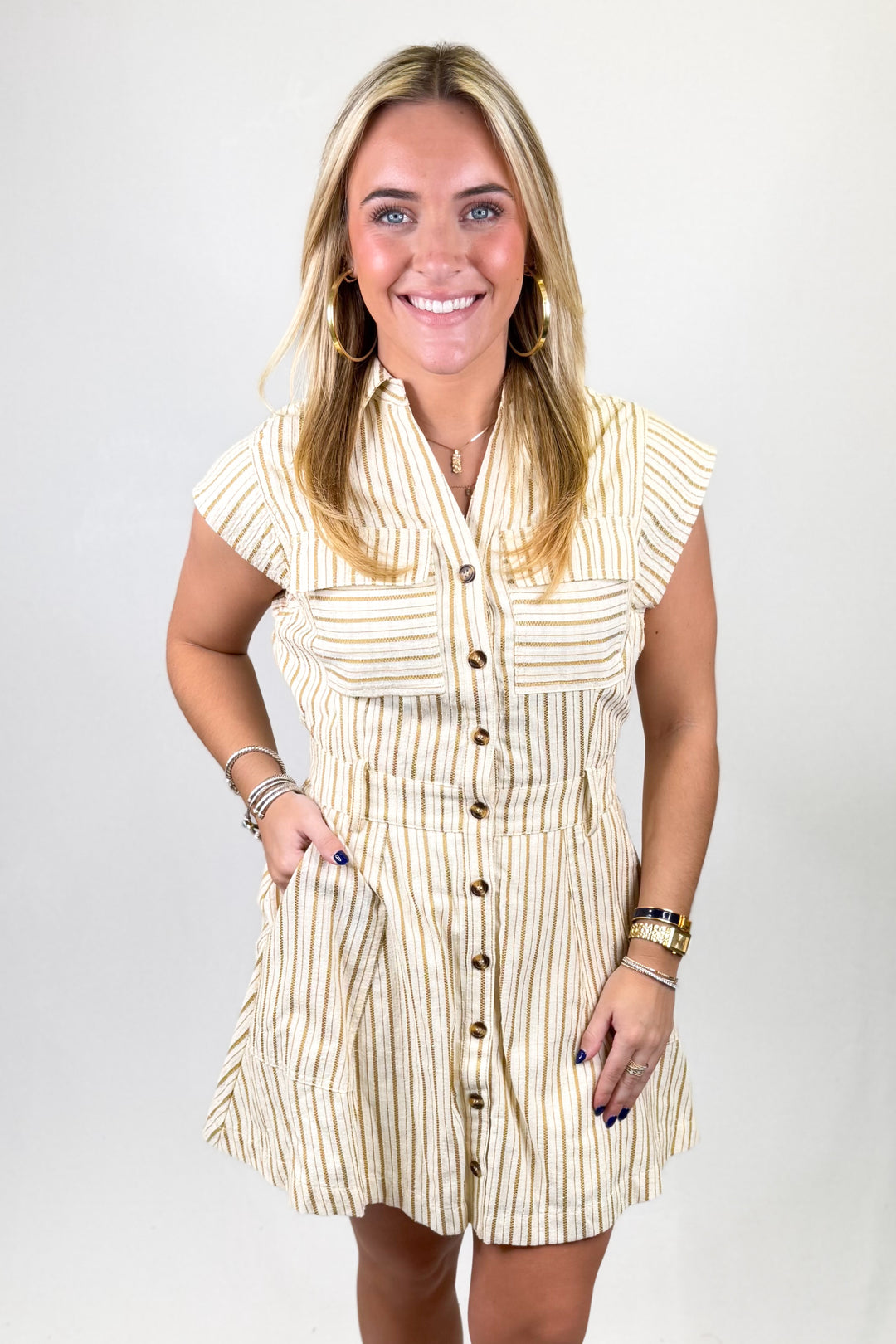 Woman wearing a striped dress with buttons on a white background