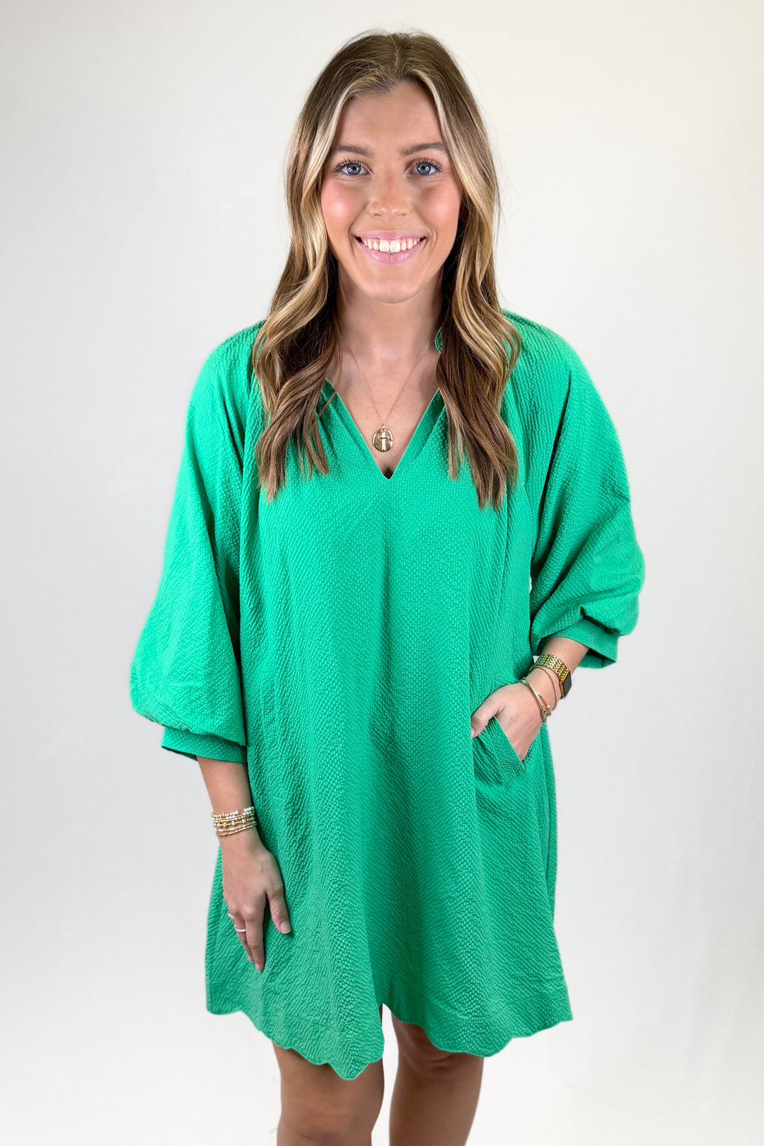 Woman wearing a green dress with a plain background