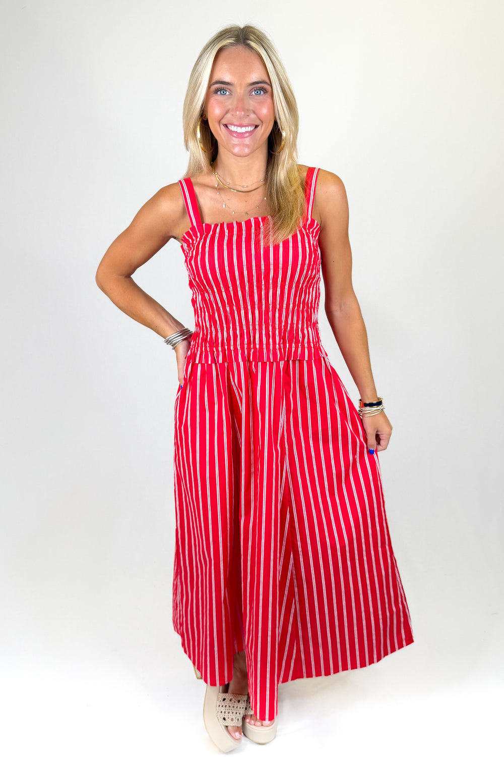 Woman wearing a red and white striped dress on a white background