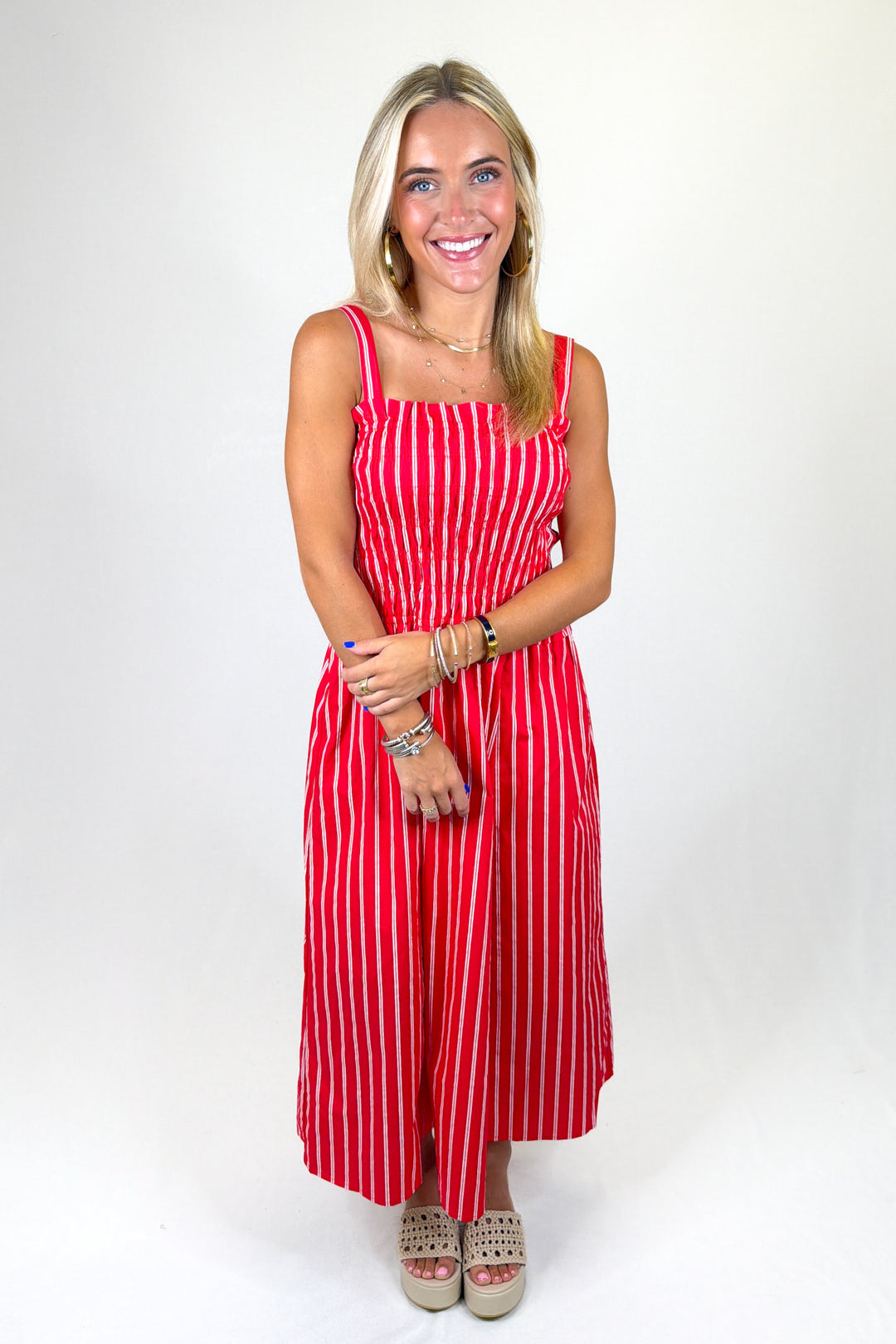 Woman wearing a red and white striped dress on a white background