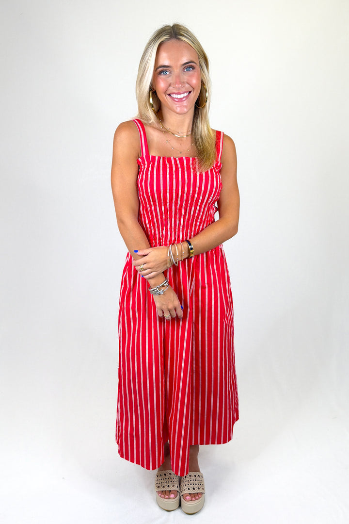 Woman wearing a red and white striped dress on a white background