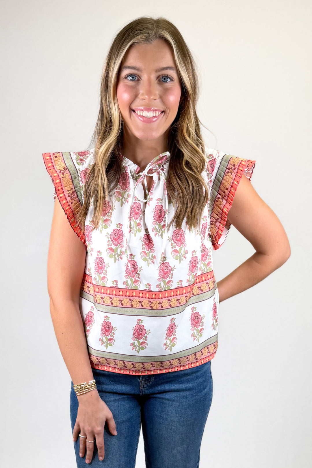Woman wearing a floral blouse with ruffled sleeves on a white background