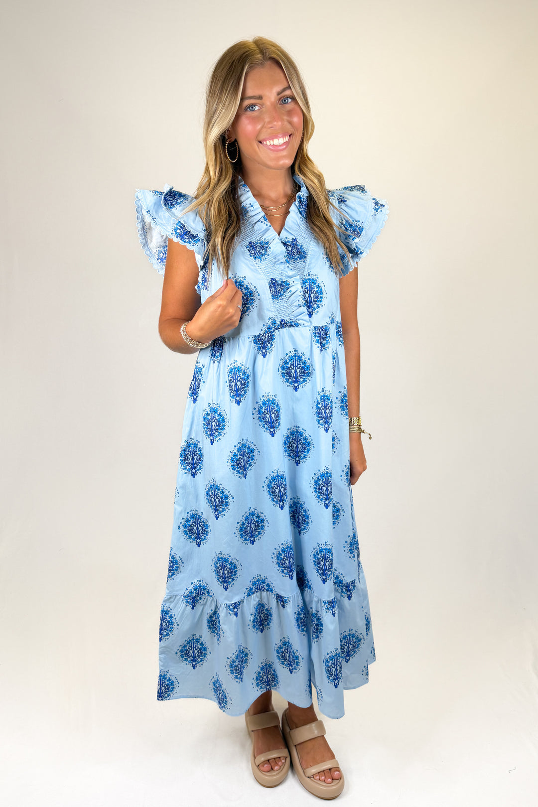 Woman wearing a blue floral dress on a white background