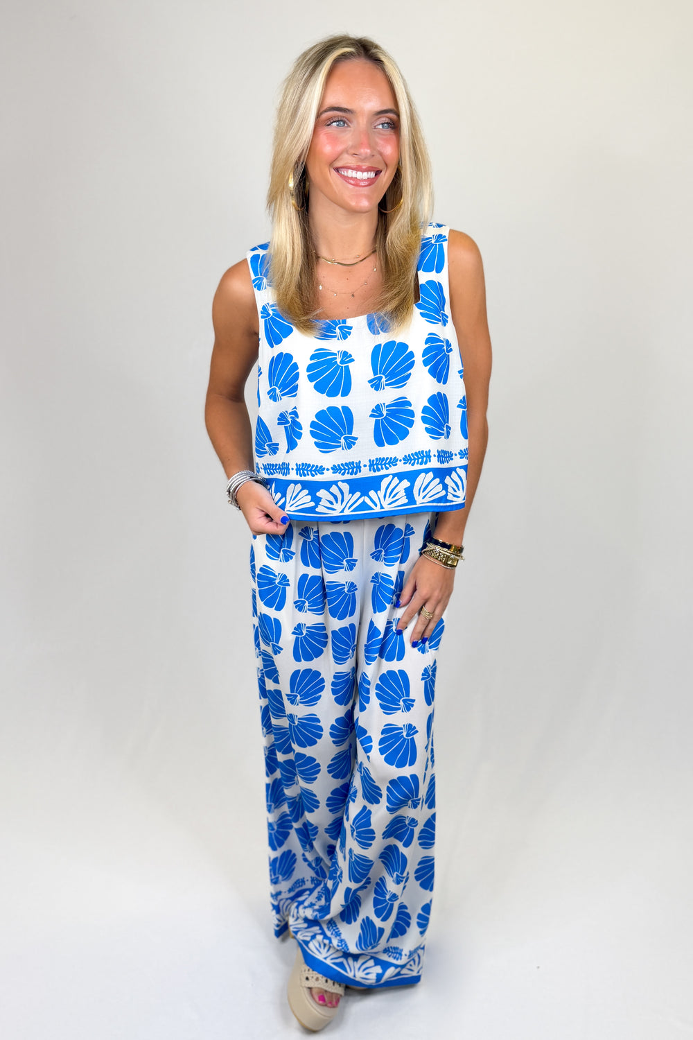 Woman wearing a blue and white floral dress on a plain background