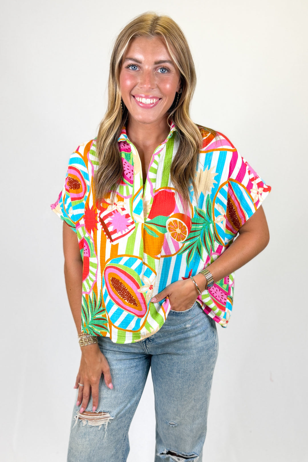 Woman wearing a colorful patterned shirt with a plain background