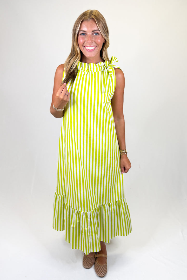 woman wearing a lime green and white striped midi dress against a white background