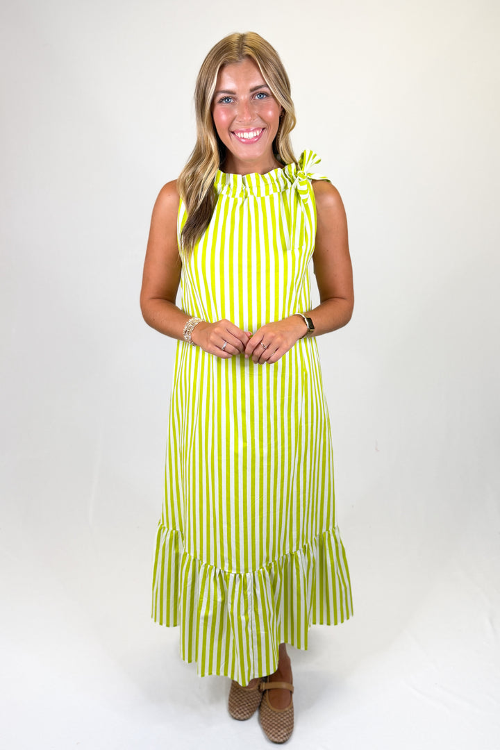 woman wearing a lime green and white striped midi dress against a white background