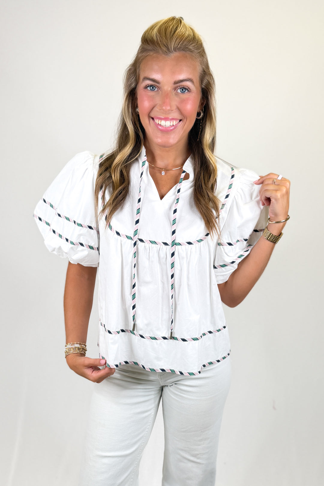 woman wearing a white puff sleeve top against a white background