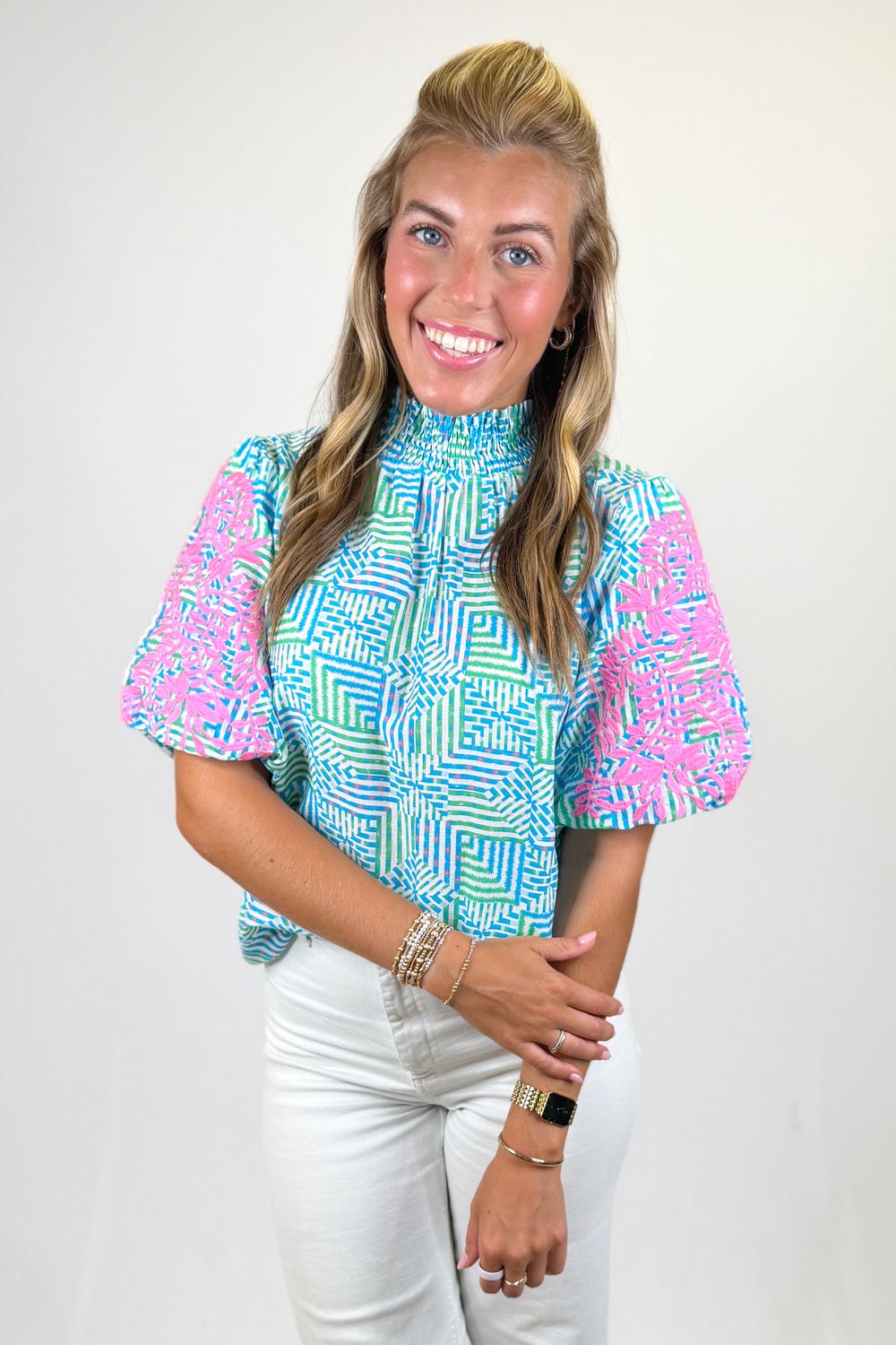 Woman wearing a colorful patterned shirt with a plain background
