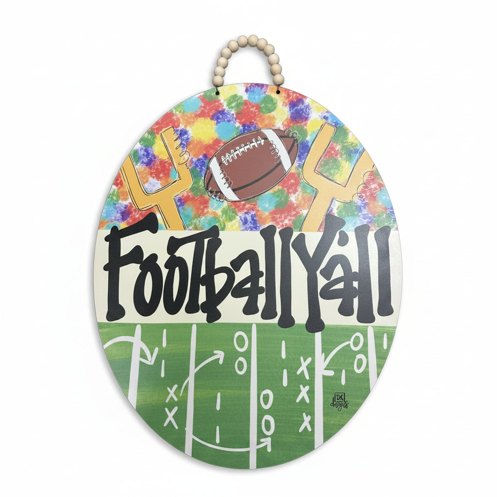 Football Y'all oval door hanger with colorful paint splatter background, football goalposts, football field play design, and bold black lettering for fall football season décor | Walker Boutique