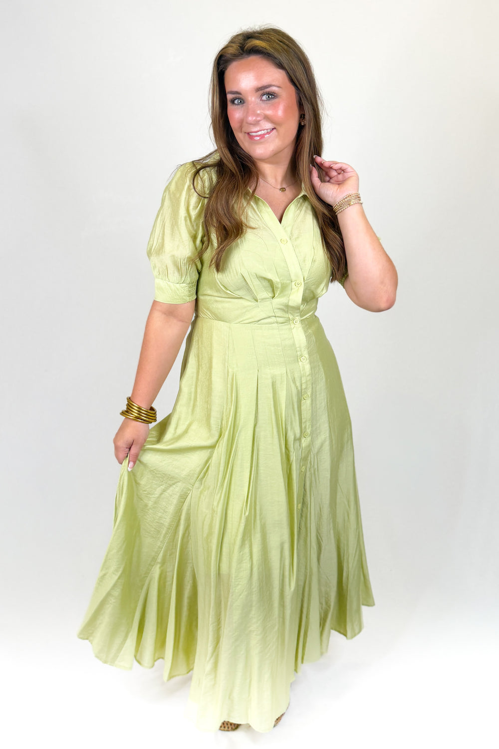 Woman wearing a light green dress against a white background