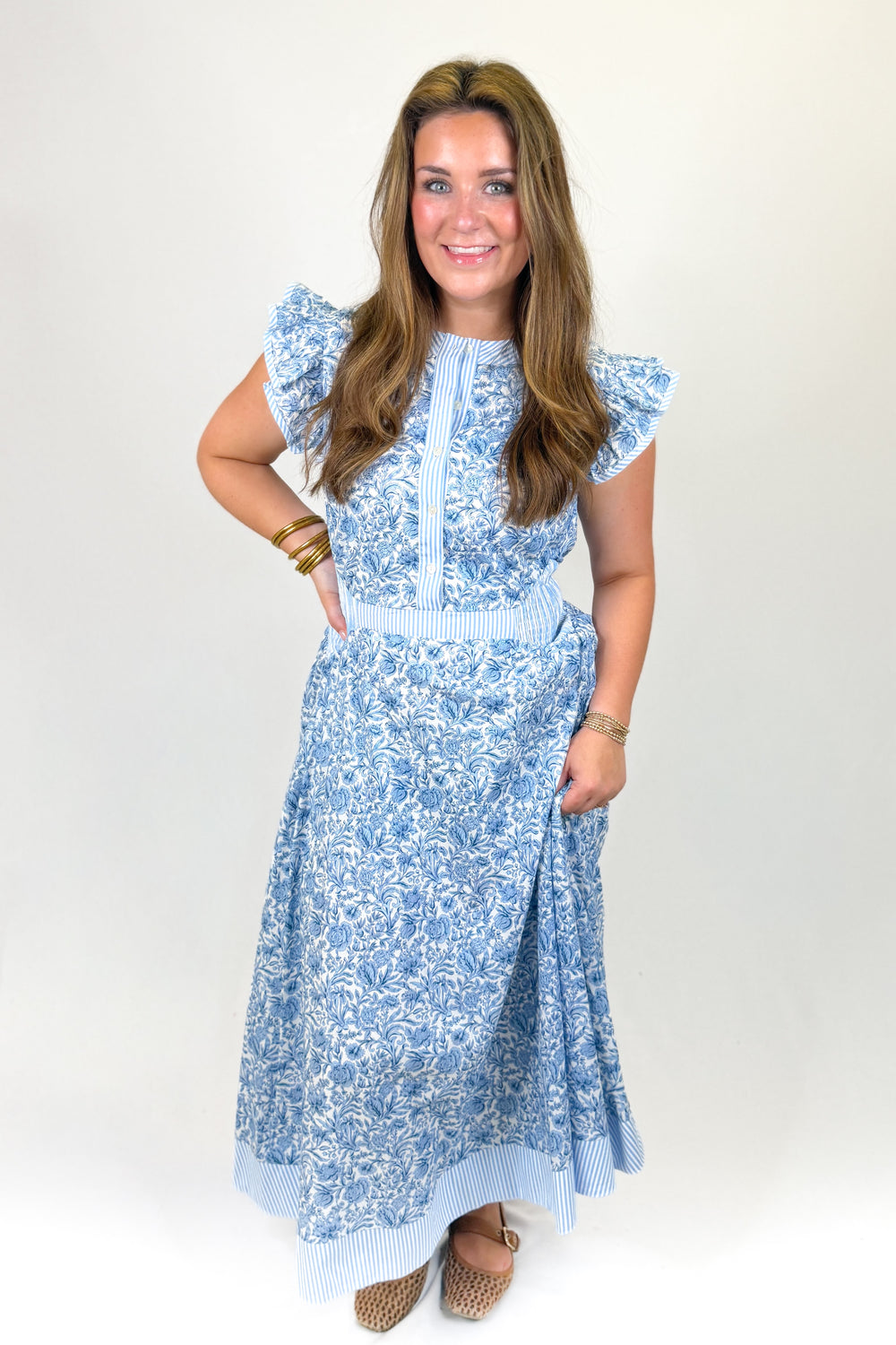 woman wearing a blue floral midi against a white background