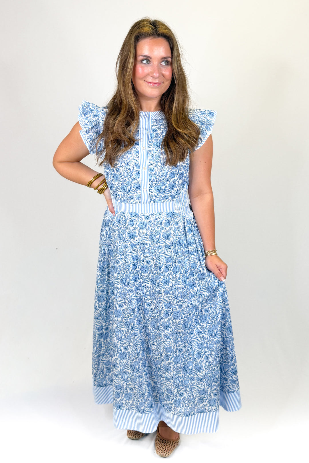 woman wearing a blue floral midi against a white background