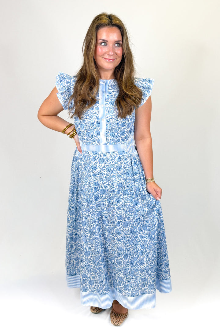 woman wearing a blue floral midi against a white background