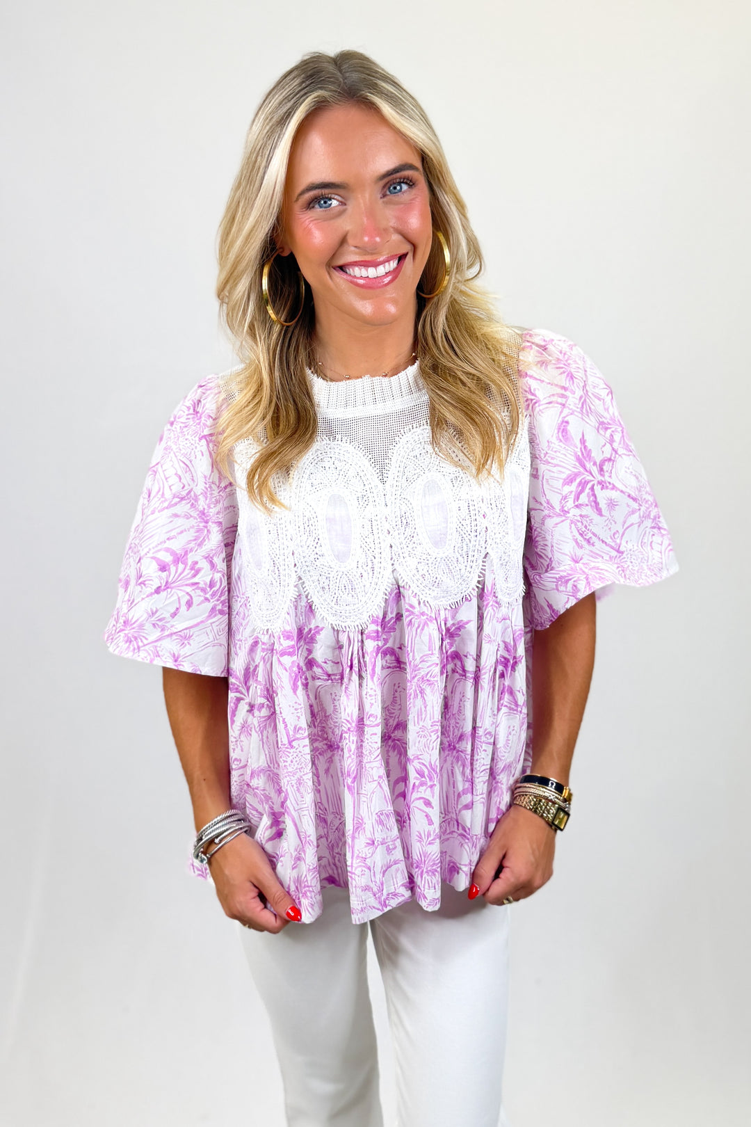 Woman wearing a pink and white patterned top with a plain background