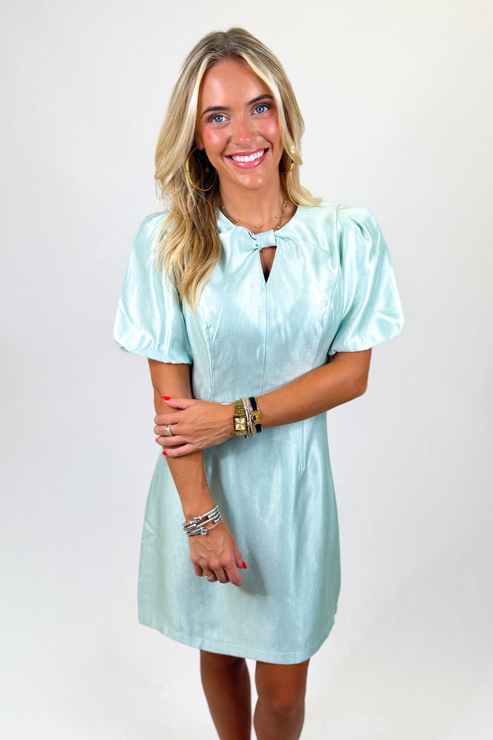 woman wearing a mint satin mini dress against a white background