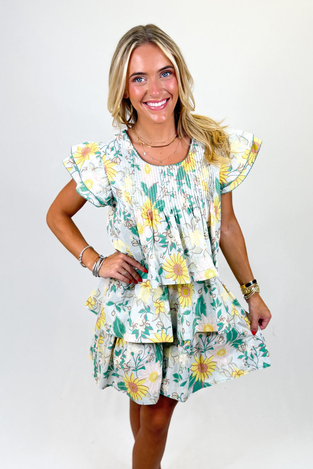 Woman wearing a floral dress with yellow flowers on a white background