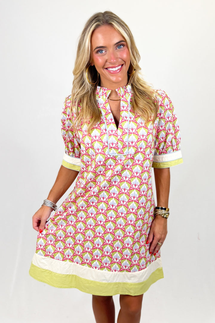 Woman wearing a patterned dress with a white background