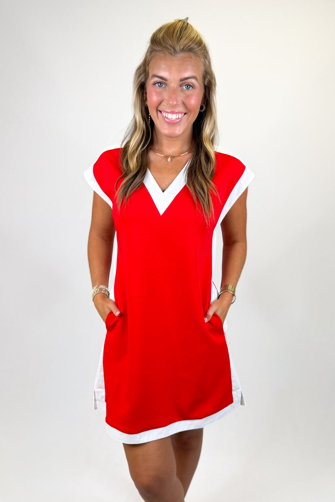 Woman wearing a red and white dress on a plain background