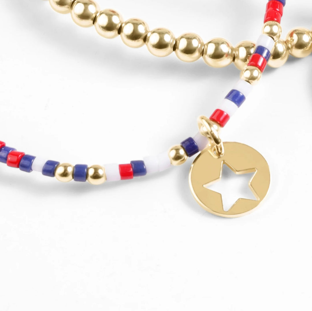 Bracelet with gold beads and star charm on a white background