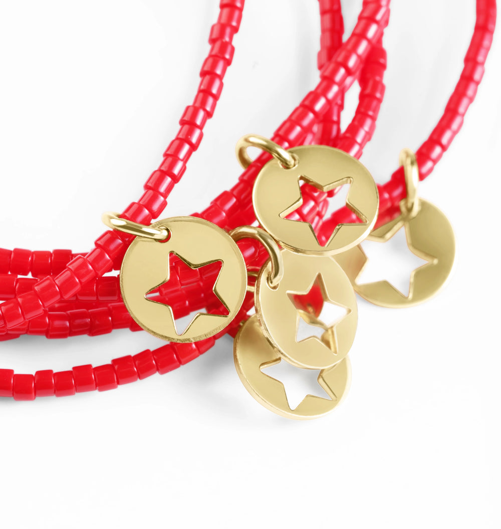 Red beaded bracelets with gold star pendants on a white background