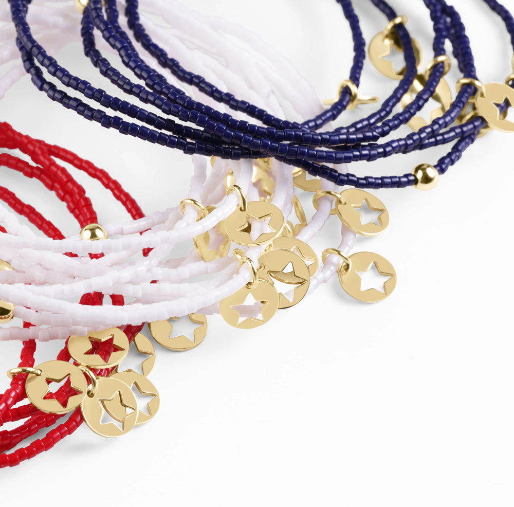Set of beaded bracelets with gold charm pendants on a white background