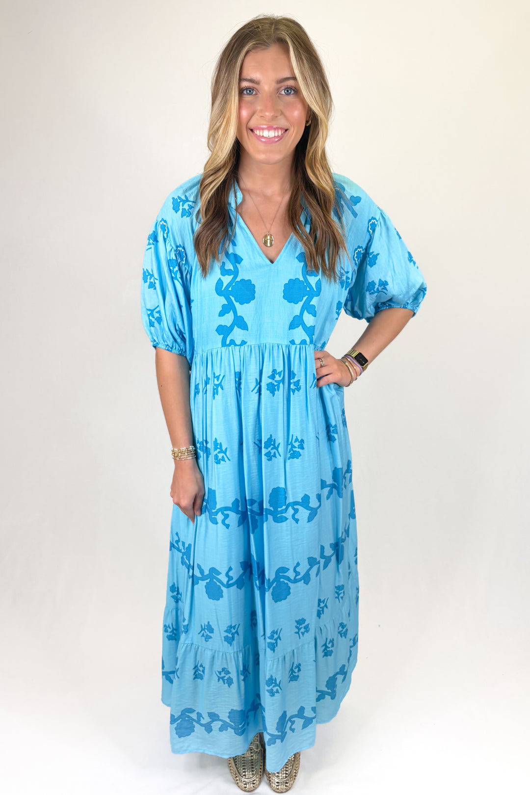 Blue maxi dress with bold blue floral print, flowy tiered skirt and puff sleeves, feminine statement dress perfect for spring and summer
