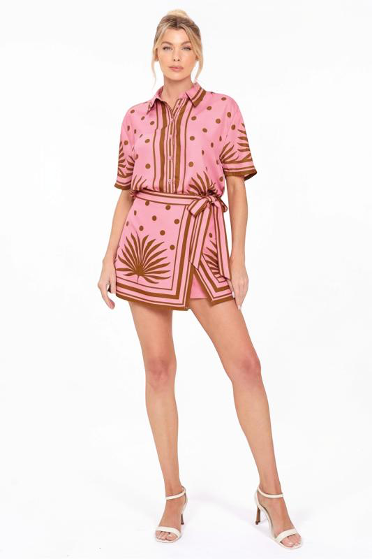 Woman wearing a pink top and skort set with a pattern on a white background