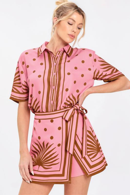 Woman wearing a pink top and skort set with brown patterns on a white background