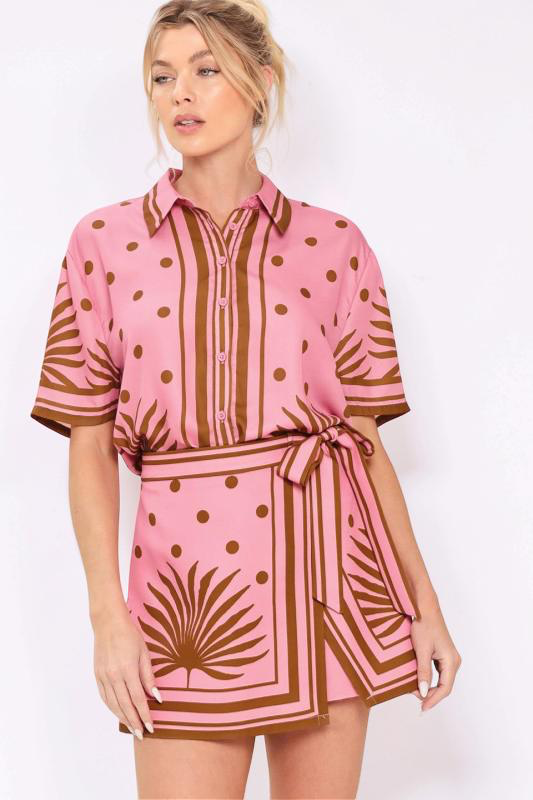 Woman wearing a pink top and skort set with brown patterns on a white background