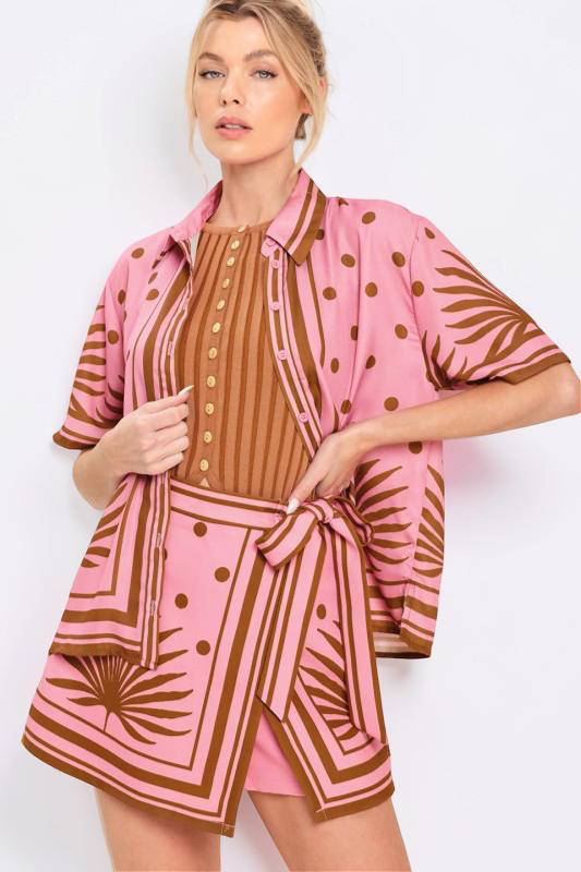Woman wearing a pink and brown patterned outfit on a white background