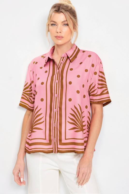 Woman wearing a pink and brown patterned blouse against a white background