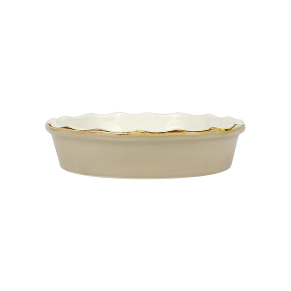 Beige ceramic dish with scalloped edge on a white background