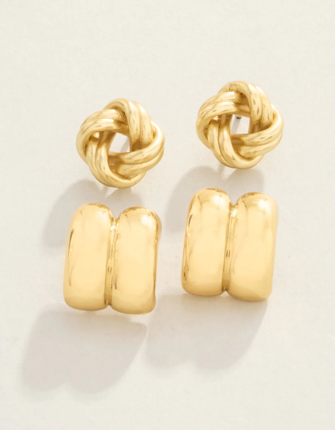 Pair of gold knot earrings on a light background