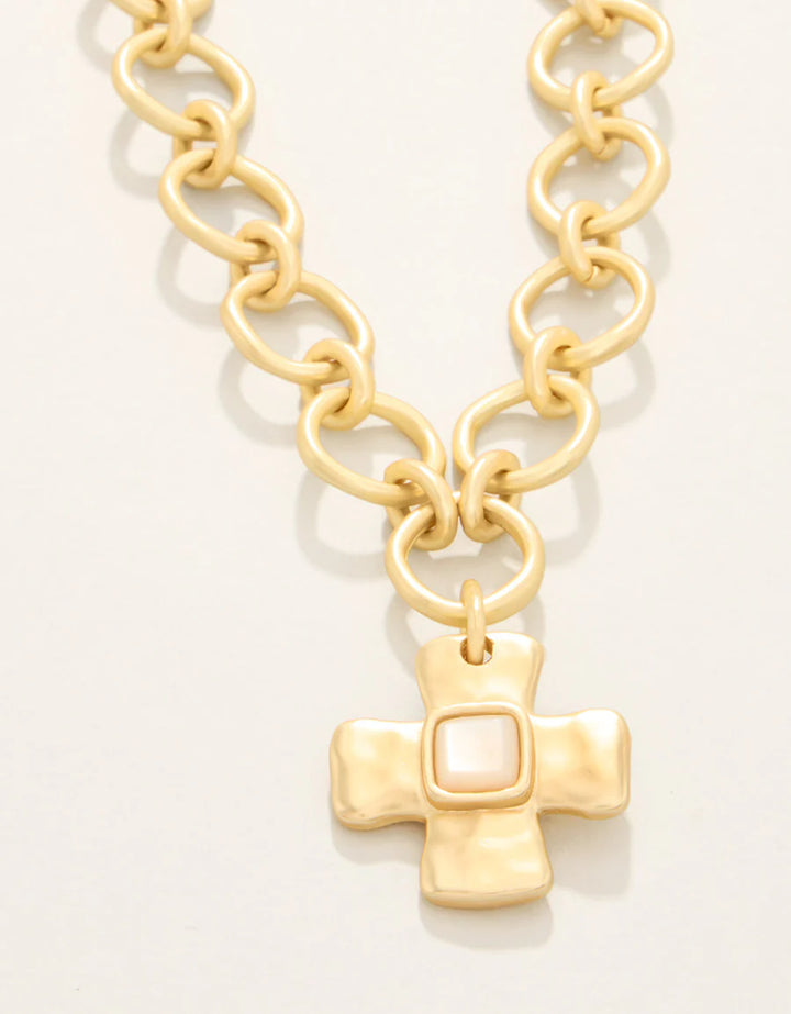 Gold chain necklace with a cross pendant on a white background