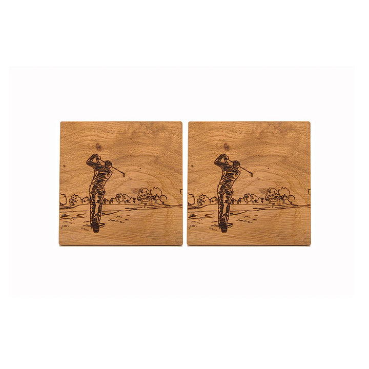 Two wooden coasters with engraved images of a golfer on a white background