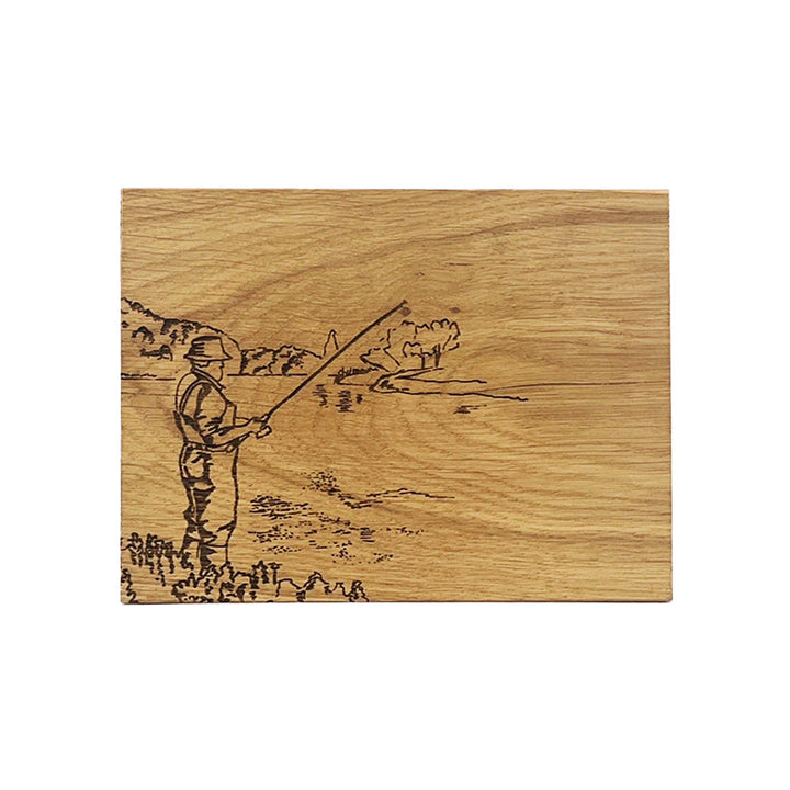 Wooden cutting board with engraved design of a person fishing