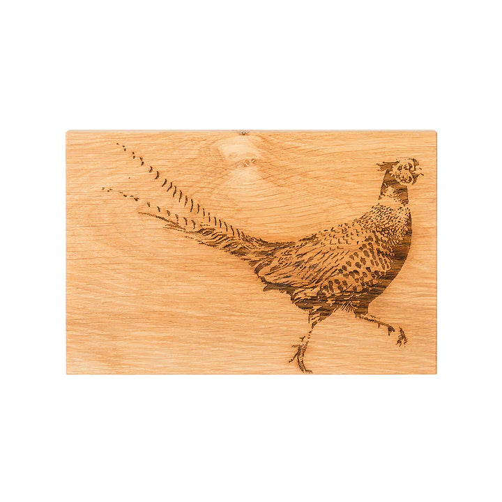 Wooden cutting board with a pheasant engraving on a white background