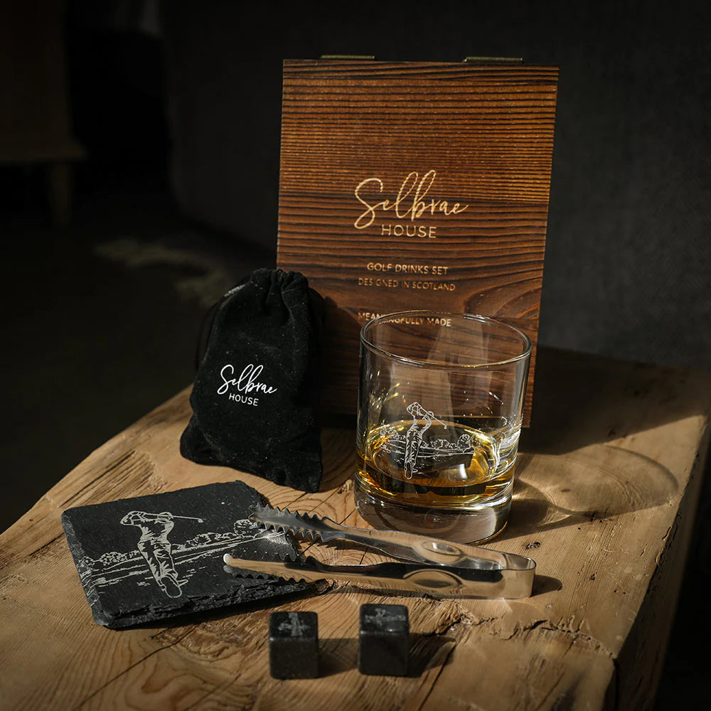 Golf drinks set with glass, coasters, and tools on a wooden surface with 'Selbrae House' branding.
