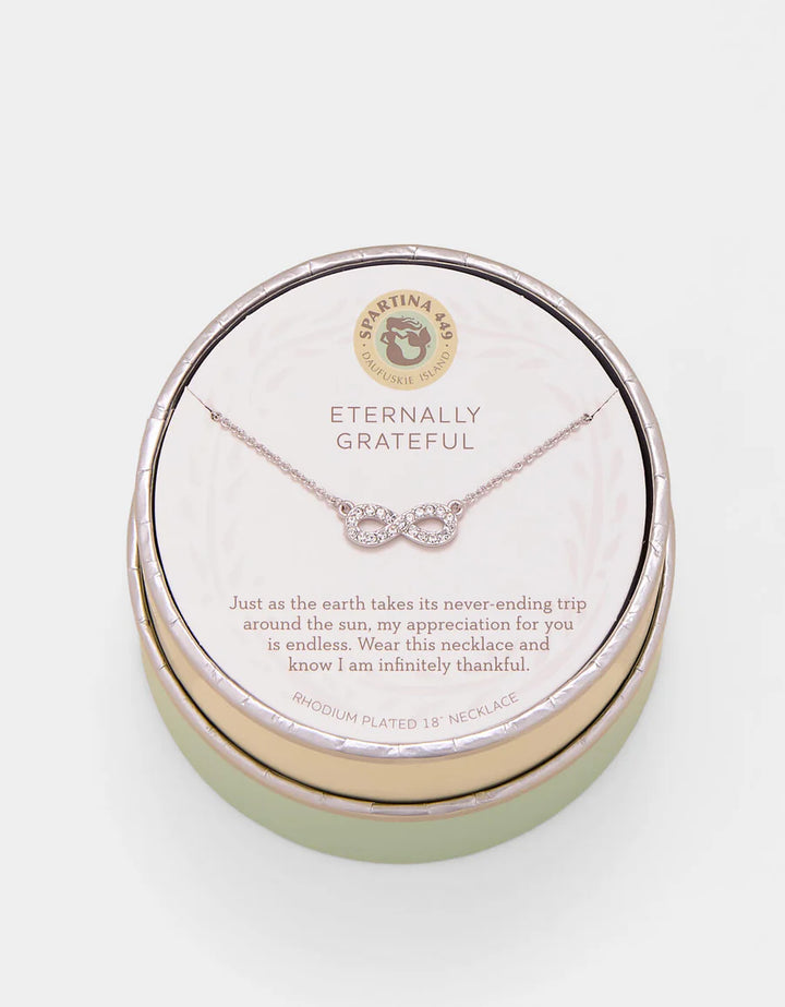 Necklace in a round jewelry box with 'Eternally Grateful' text on a light background