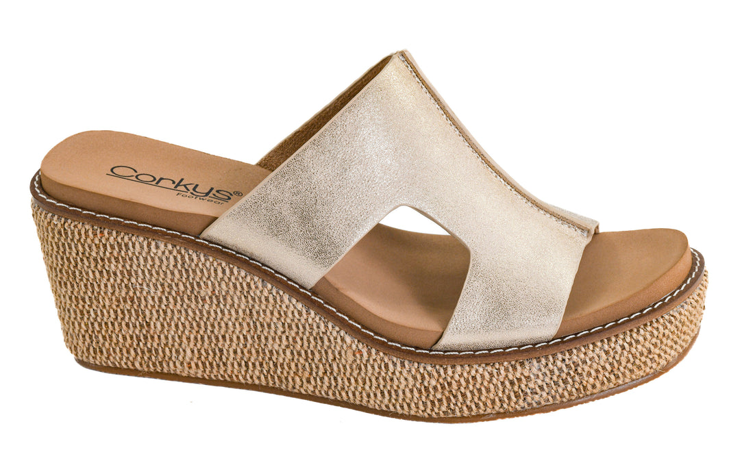 Gold wedge sandal with cork sole on a white background