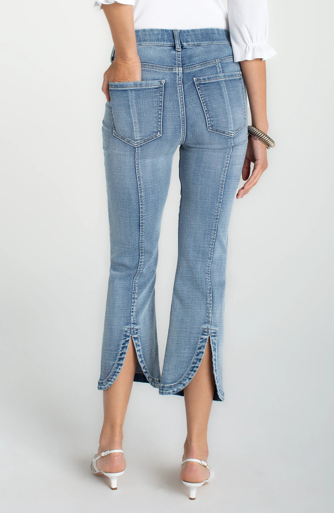light wash high rise cropped jeans with slim leg and split hem detail shown from back