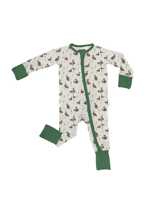 A baby long-sleeve footed sleeper with an all-over duck print on an off-white background, featuring solid green cuffs, collar, and zipper trim.