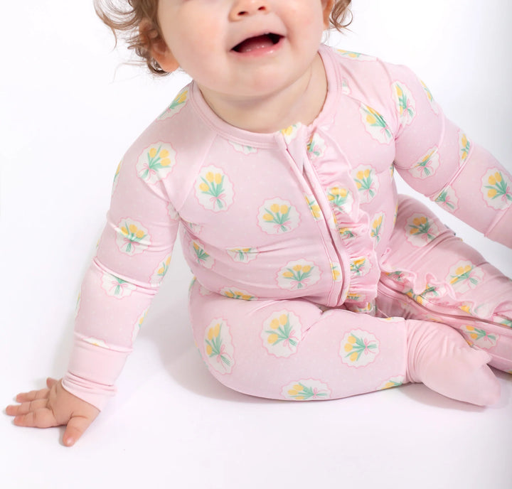 Baby wearing a pink floral onesie on a white background