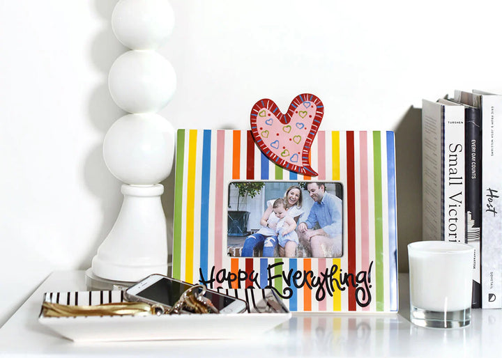 Colorful striped photo frame with heart design on a white surface