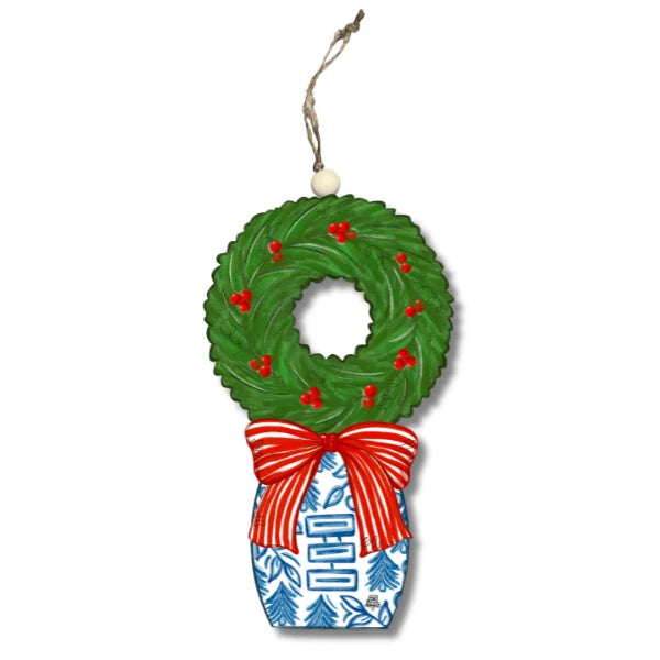 Decorative Christmas ornament shaped like a wreath with a red bow on a white background